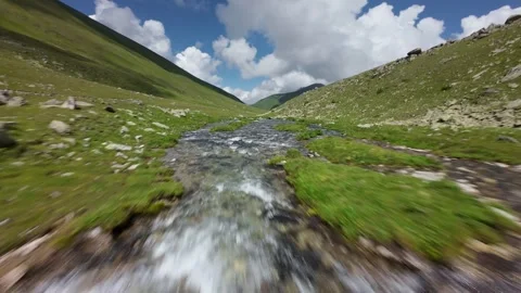 Fast forward drone flight over mountain stream and valley Video stock 343738969