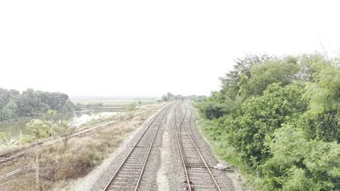 Fast Forward Drone View Over Railway Tracks Curving Through a Scenic Landscape Stock Footage 338007773