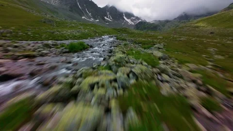 Fast forward fpv tracking shot over mountain stream and rocks Video stock 345710835