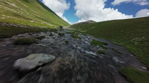 Fast forward tracking shot over mountain stream and valley Video stock 345088571