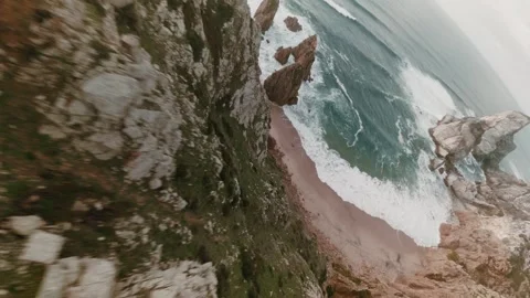 Fast FPV cliff dive from rugged green cliffside into secluded rocky Atlantic Stock Footage 336201977