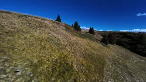 Fast fpv drone flight over alpine meadows and mountain hills Stockbeeldmateriaal 327013475