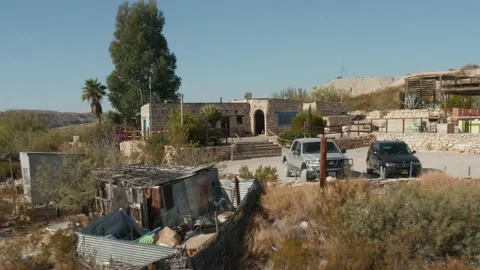 Fast Long reverse of house on top of hill in the middle of a desert western town Stock Footage 145021484