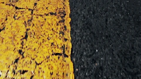 Fast Low-Angle Flight Over Worn Yellow Road Line and Asphalt Texture Stock Footage 348175473