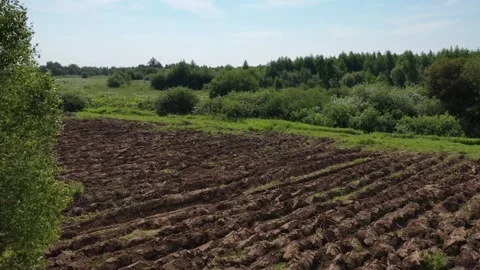 Fast low drone orbit over plowed field Kolomna Stock Footage 327553981