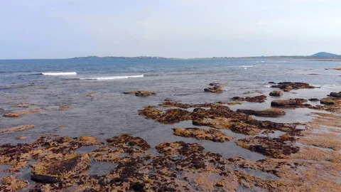 Fast low flying drone over rocks and sea Stock Footage 91092183