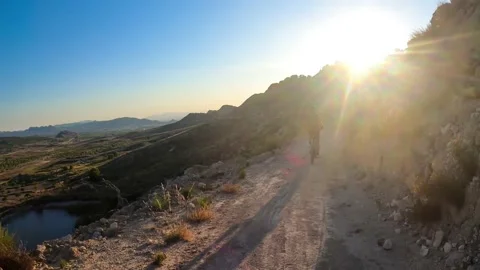 Fast motion of biker riding through path way in beautiful landscape 库存影片 133337326