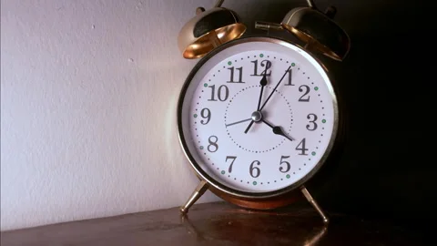 Fast-Motion Golden Alarm Clock Shot from Left in Deep Shadow Stock Footage 336259506