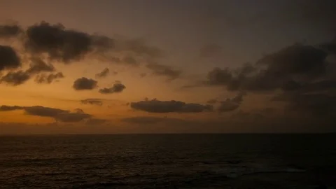 Fast motion of orange and amber dusk over seascape with ocean waves, 4K 30p Stock Footage 75397575