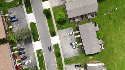 Fast-motion scene of a car winding through a suburban road flanked by manicured Stock-Footage 311804928