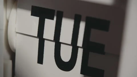 Fast Motion of Weekly Name Cards Transitioning on Vintage Tabletop Clock Stock Footage 330925063
