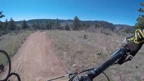 Fast Mountain Biking using action cam and stabilization on blue sky view Stockbeeldmateriaal 89560550