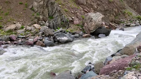 Fast mountain stream with rocks and rugged riverbank in valley Stock Footage 310247205