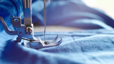 Fast movement of the sewing machine needle on the blue fabric. The needle of the Stock Footage 132178251
