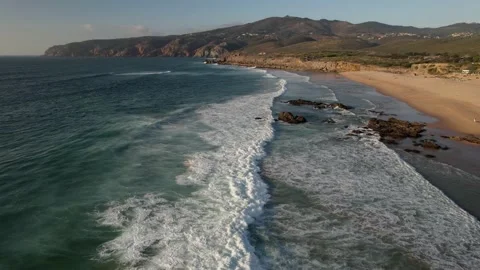 Fast moving aerial drone view of beachgoers and surfers at Guincho Beach in Stock Footage 211897364