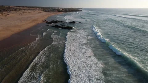 Fast moving aerial drone view of beachgoers and surfers at Guincho Beach  Stock Footage 211903737