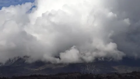 Fast moving cloud formation boiling over a mountain Stock Footage 158761213