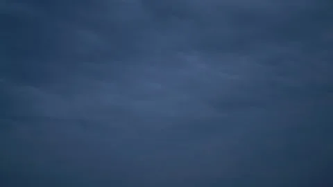 Fast-moving clouds across the sky smoothly turning into twilight Stock Footage 220621264