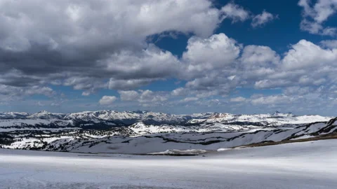 Fast moving clouds and shadows over snowy mountain landscape in spring Stock Footage 167110685
