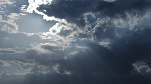Fast moving clouds in blue sky with sun and sunbeams shining through them Stock Footage 49990501