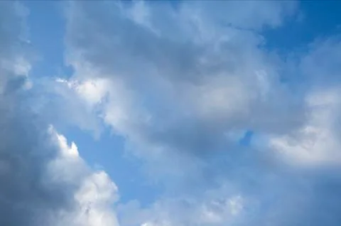 Fast moving clouds during a sunny day in the blue sky with the transition to  스톡 사진