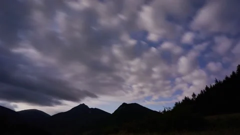 Fast moving clouds in the night sky. Silhouette of a mountain landscape Stock-Footage 171381466