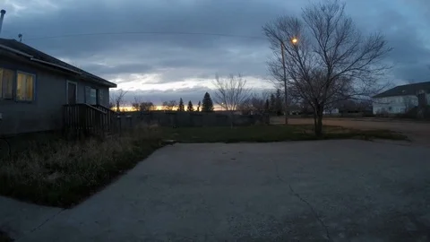 Fast moving clouds over the front yard of a house in a small town called Stock Footage 107823599