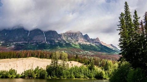 Fast moving clouds over mountain with slow pan up Stock Footage 128408250