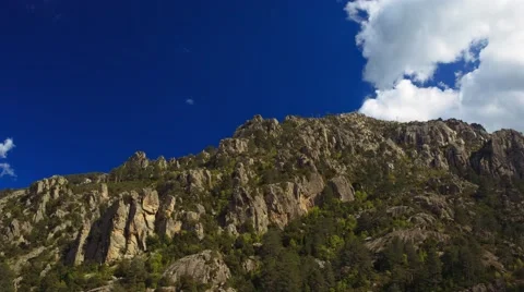 Fast moving clouds over rocky mountains, shadows running, cinematic time-lapse Stock Footage 40201494