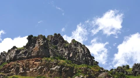 Fast Moving Clouds Over a Rocky Hill Stockbeeldmateriaal 53232561