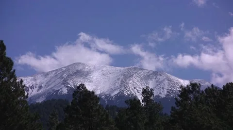 Fast moving clouds over a snow capped mountain Stock Footage 59129518
