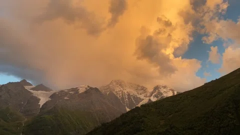 Fast-Moving Clouds Over Snowy Mountains at Sunset Stock Footage 315031555