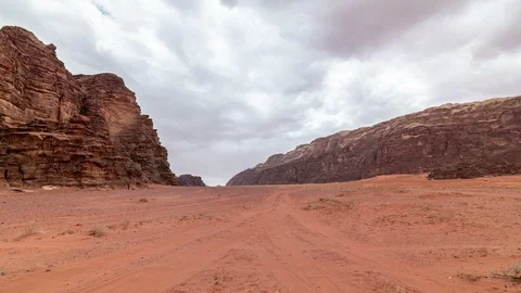 Fast moving clouds over stone desert landscape, red rocks and sand Stock Footage 109074514