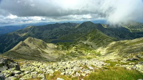 Fast moving clouds over sunny mountain peak Stock Footage 93691836
