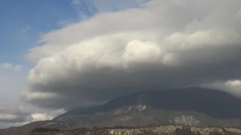 Fast moving clouds traveling over a mountain timelapse Stock Footage 158761337