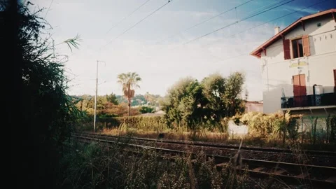 A fast moving double decker train rushes past railway tracks surrounded by wild Stock Footage 323056042