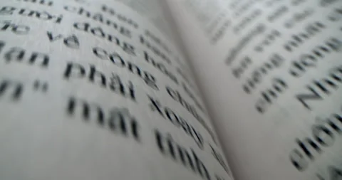 Fast moving macro view past inside of book on a black background close-up of a Stock Footage 247827373