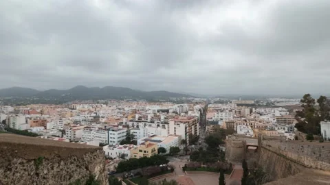 Fast moving rain clouds over the beautiful white houses in the town of Ibiza Stock Footage 175865644