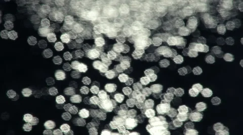 Fast moving shining sparkles on dark background. Vidéo 47012094