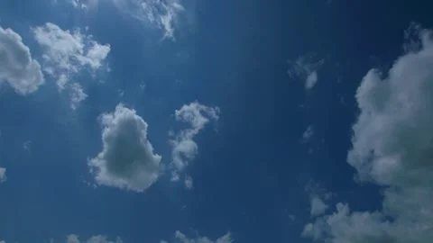 Fast moving summer clouds passing beneath bright sun, timelapse Stock Footage 333614749