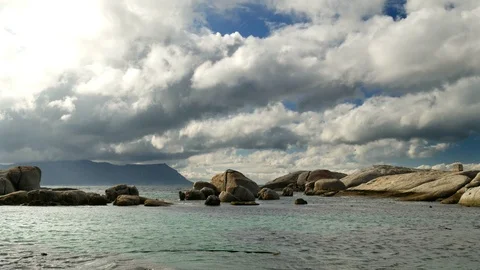 Fast moving time lapse white and grey clouds over a pulsating rock pool Vidéo 113573551