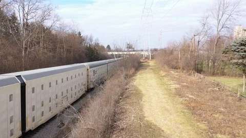 Fast Moving Train Next To Pathway in USA Midwest in March, Aerial drone, 4k Stock Footage 124902083