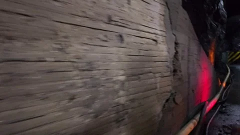 Fast Moving View Along Timber Lined Mine Wall With Red Light, Colombia 8K Stock Footage 331525037