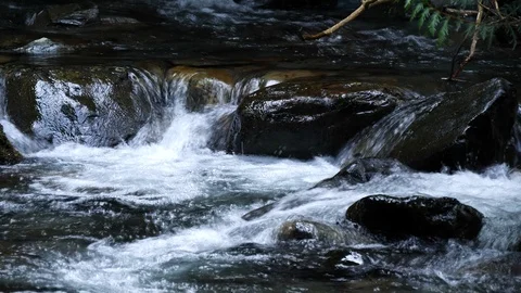 Fast moving water down stream across rocks Stock Footage 104909416