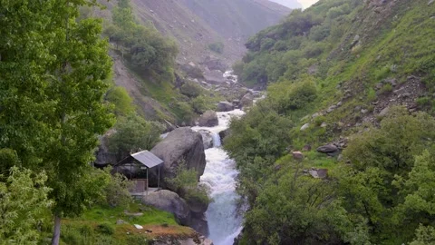 Fast moving water stream coming from snow-capped mountain near Sissu Stock Footage 211815534