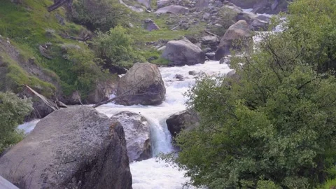 Fast moving water stream coming from snow-capped mountains Stock Footage 211815614