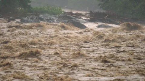 Fast muddy floodwaters rush through river channel with violent flow - Fast Water Vidéo 339750588