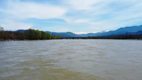 Fast muddy river drone facing upstream right above the surface Stock Footage 241219703