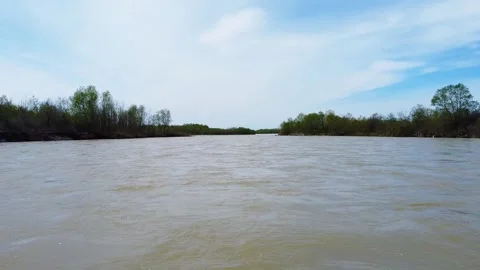 Fast muddy river drone facing downstream right above the surface Stock Footage 241220324