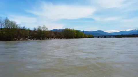 Fast muddy river drone pan left to riverside Stock Footage 241219739